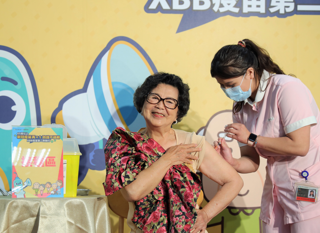 防疫大使王滿嬌女士於記者會現場示範接種XBB疫苗，呼籲符合資格的民眾踴躍接種。(陳瑾瑜拍攝)