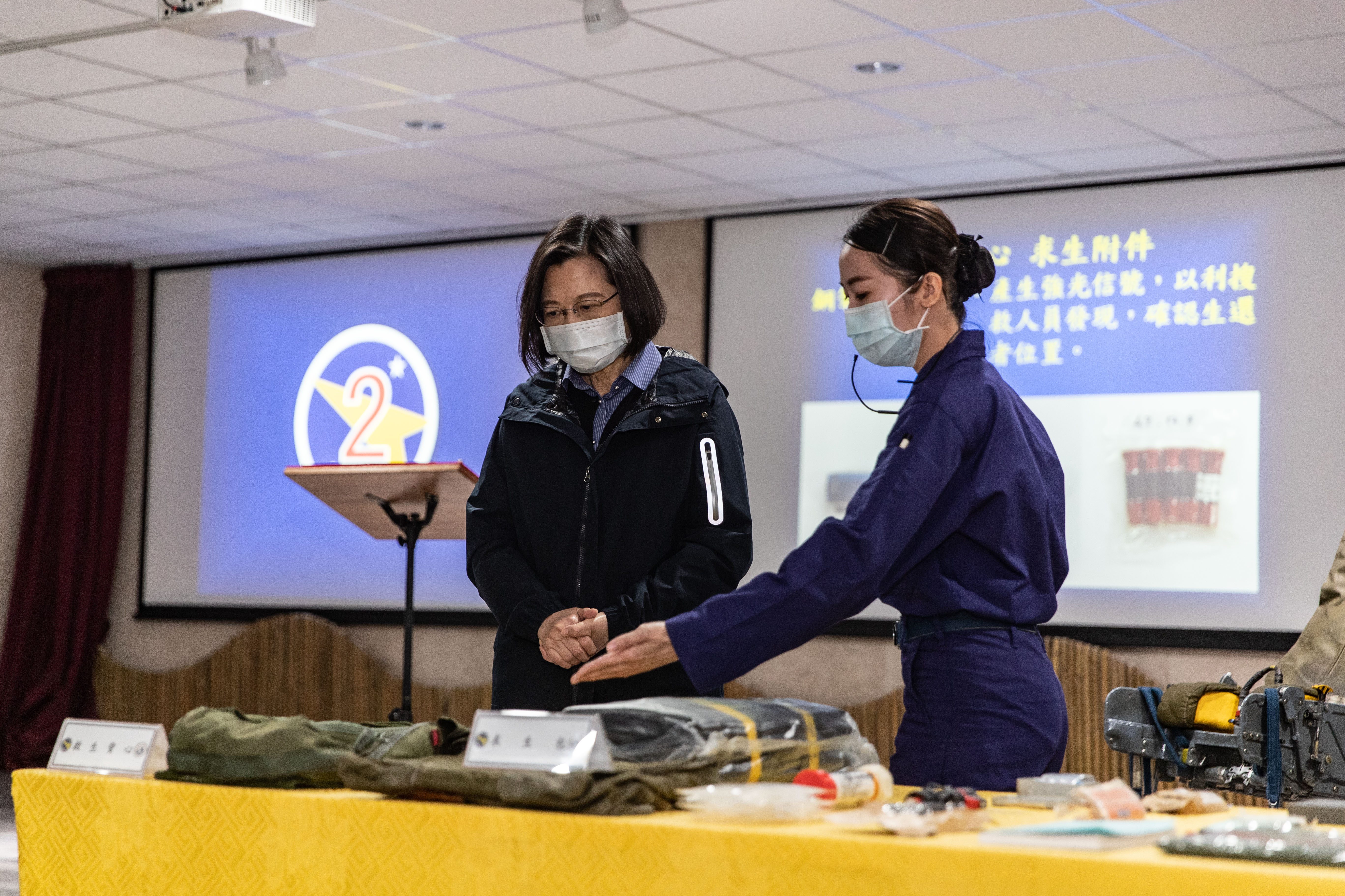 空軍第二戰術戰鬥機聯隊上士劉糖蓁（右），向蔡總統介紹拯救幻象飛官黃重凱設置於幻象機身上的貝克馬丁彈射椅及救生背心等裝置。（圖／軍聞社提供）